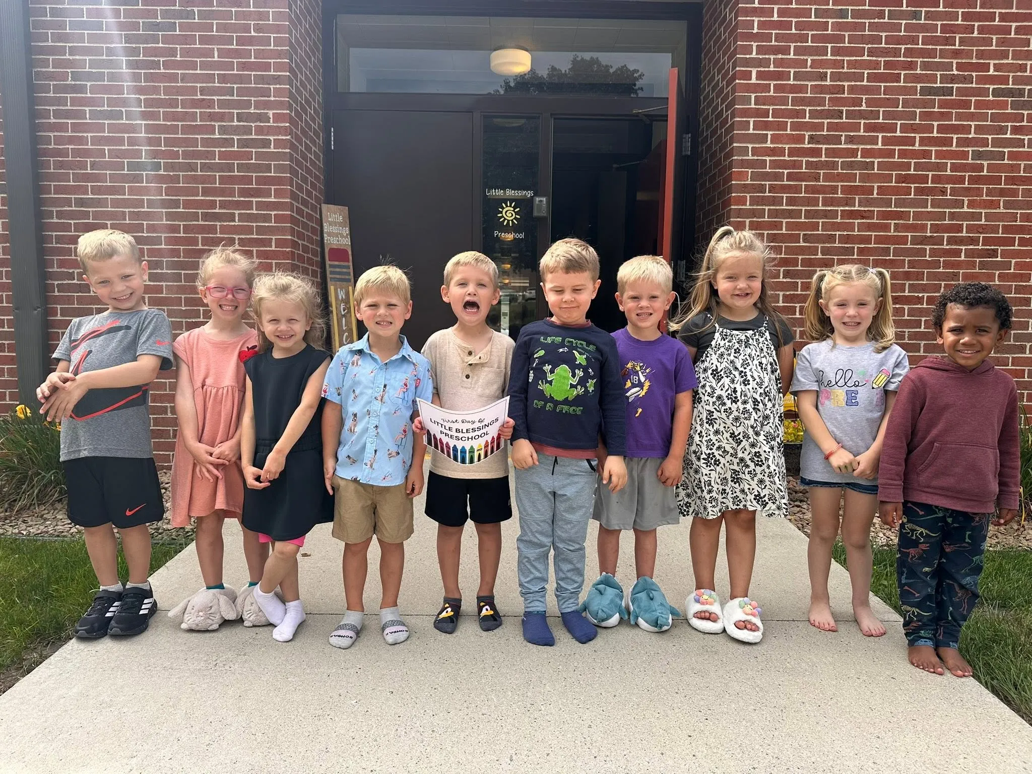 Little Blessings preschoolers lined up smiling on their first day of school outside the church entrance